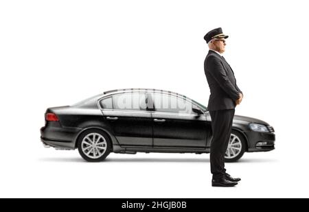 Ganzkörperaufnahme eines Chauffeurs, der neben einem schwarzen Auto auf weißem Hintergrund steht und wartet Stockfoto