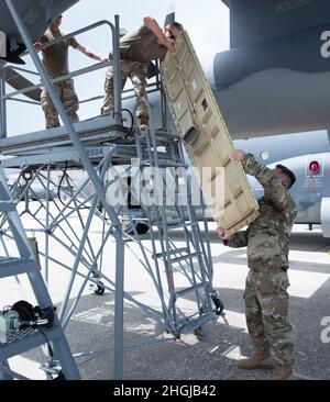 U.S. Air Force Master Sgt. Ryan Pittman, rechts, Spezialist für elektrische Systeme des 720. Flugzeugwartungsgeschwaders, übergibt ein Motorpanel an Staff Sgt. Evan O’Connell, 720. Spezialist für elektrische AMXS-Systeme, 16. August 2021, während der Wartung eines HC-130J Combat King II auf der Patrick Space Force Base, Florida. Pittman beaufsichtigt den Wartungsbetrieb, als Mitglieder des 720. AMXS eine Überhitzungsschleife im Flugzeug ersetzten. Stockfoto