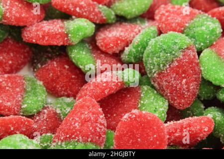 Kauen Erdbeer-förmige Marmelade rot mit grün in Zucker Nahaufnahme von Lebensmitteln Hintergrund. Stockfoto