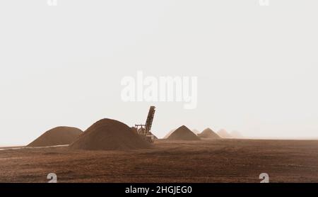 Torf- und Baggerhaufen an einem nebligen Morgen. Stockfoto