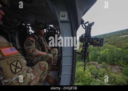 U.S. Army Command Sgt. Maj. Mario Terenas, der Oberfeldwebel Major der 10. Bergdivision, führt am 18. August 2021 in Fort Drum, NY, mit einem 2-10 Assault Helicopter Bataillon Luftgewehrschießen durch. Die Luftpistole bestand darin, aus einem UH-60M Black Hawk einen M240H zu schießen und dabei Bodenziele zu treffen. Stockfoto