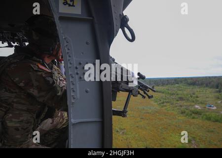 U.S. Army Command Sgt. Maj. Mario Terenas, der Oberfeldwebel Major der 10. Bergdivision, führt am 18. August 2021 in Fort Drum, NY, mit einem 2-10 Assault Helicopter Bataillon Luftgewehrschießen durch. Die Luftpistole bestand darin, aus einem UH-60M Black Hawk einen M240H zu schießen und dabei Bodenziele zu treffen. Stockfoto