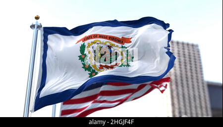 Die Flagge des US-Bundesstaates West Virginia winkt im Wind, die amerikanische Flagge verschwimmt im Hintergrund. Stockfoto