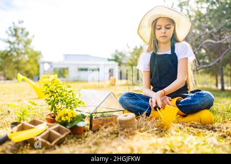 Schöne Schülerin Teenager Zeit im Freien im Garten tragen Strohhut Stockfoto