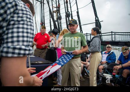 BOSTON (20. August 2021) der Gast faltet eine Flagge mit Sailor während eines Anfahrens zu Ehren der Vietnam Veteranen und ihrer Familien an Bord der USS Constitution. USS Constitution, das älteste in Auftrag gegebene Kriegsschiff der Welt, spielte eine entscheidende Rolle in den Barbarenkriegen und dem Krieg von 1812 und verteidigte von 1797 bis 1855 aktiv die Seewege. Während des normalen Betriebs bieten die an Bord der USS Constitution stationierten Aktivsegler kostenlose Touren an und bieten jährlich mehr als 600,000 Menschen öffentliche Besichtigungen an, da sie die Mission des Schiffes unterstützen, die Geschichte und das maritime Erbe der Marine zu fördern und einen Awar zu schaffen Stockfoto