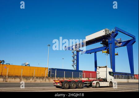 Container-LKW im Hafen von Bilbao mit Containern und Kran im Hintergrund, Santurce, Biskaya, Baskenland, Euskadi, Spanien Stockfoto