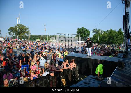 Der US Marine-Kapitän Justin Hebert, der Operations Officer der Recruiting Station (RS) Cleveland, stellt sich vor und bereitet die Menge auf eine Eid-in-Zeremonie auf dem Cuyahoga County Fairgrounds während des Wgar's 99.5 Country Jam in Middleburg Heights, Ohio, am 21. August 2021 vor. Die Veranstaltung ermöglichte es den Rekrutierern, sich mit der lokalen Gemeinschaft zu engagieren und Zivilisten einzuladen, an einer Pull-up-Herausforderung teilzunehmen, um Preise für das Marine Corps zu erhalten. Während des Konzerts hielt RS Cleveland eine Eid-Zeremonie ab, um das Bewusstsein für das Marine Corps zu schärfen. Stockfoto