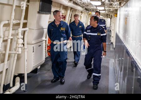 210824-N-PC065-1043 KARIBISCHES MEER - (AUG 24, 2021) - Kapitän Peter Ehlers, links, Kommandant der Destroyer Squadron 40, spricht mit der französischen Marine Frigate Capt. Chun Jen Fang, Kommandant der Floréal-Klasse Fregatte FS Germinal (F735), während einer Tour des amphibischen Transportschiffes USS Arlington (LPD 24) der San Antonio-Klasse am 24. August 2021. Der Besuch von Fang ermöglichte es der Führung, bewährte Praktiken auszutauschen, während sie gemeinsam auf das gemeinsame Ziel hinarbeiten, die humanitären Hilfsbemühungen in Haiti zu unterstützen. Arlington wird bei den U.S. Naval Forces Southern Command/U.S. eingesetzt 4. Flotte zur Unterstützung der Humanitaria Stockfoto