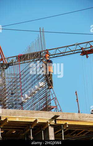 Dnipropetrovsk, Ukraine - 11.22.2021: Ein Arbeiter bereitet einen Rahmen aus dem Balken vor, um Beton in einen tragenden Balken eines Wohngebäudes zu gießen. Stockfoto