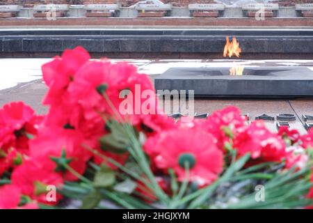 Brest, Weißrussland - 12. Januar 2022: Rote Nelken an der Gedenkstätte. Ewige Flamme. Erinnerung an gefallene Soldaten. Mai 9 Stockfoto