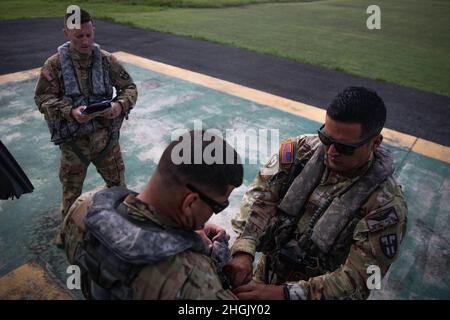 Chief Warrant Officer Three (CW3) Norberto Martinez (rechts) passt den Flotationskragen LPU-4 von Sgt an. Francisco Silva (links) vor der Abreise nach Port-au-Prince, Haiti, 25. August 2021. Die UH-72-Besatzungsmitglieder der Puerto Rico Army National Guard Aviation waren ein wesentlicher Teil der von der USAID geleiteten Hilfsmaßnahmen, indem sie Aufklärungsflüge mit dem Ziel durchführten, den Zustand einer Vielzahl lokaler Infrastrukturen wie Krankenhäuser, Schulen und Straßen aus der Luft zu beurteilen. Stockfoto