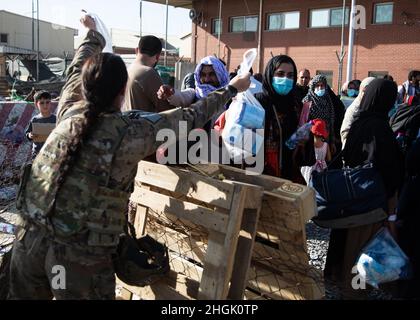 Ein Fallschirmjäger der 82. Luftlandedivision gibt am Hamid Karzai International Airport in Kabul, Afghanistan, Taschen mit Babyartikeln aus, die für ein Kleinkind zur Fahrt benötigt werden, am 26. August 2021. Das Laufwerk wurde von der 82. ABN gehostet. Div. Kaplan's Office, das Babynahrung, Windeln, Saft, Babynahrung und Cracker für die Verteilung an afghanische Familien beschafft hat, die das Land evakuieren. Die Vorräte sollen dazu beitragen, die Familien auf ihrer Reise zu unterstützen. Stockfoto