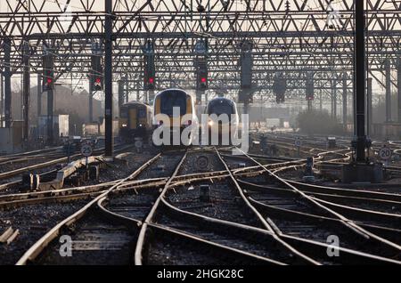 Northern Rail, Crosscountry und Virgin Züge, die mit roten Signalen an der geschäftigen Manchester Piccadilly Station Throat fahren Stockfoto