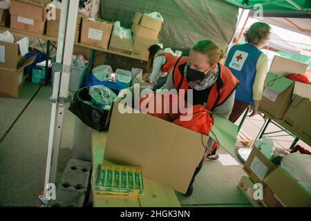 Mitglieder des Roten Kreuzes bereiten sich auf die Ankunft von Evakuierten aus Afghanistan im Rahmen der Operation Allies Refuge auf dem Luftwaffenstützpunkt Ramstein, Deutschland, am 27. August 2021 vor. Das Rote Kreuz stellte Evakuierten persönliche Hygieneartikel, Lebensmittel und andere Notwendigkeiten zur Verfügung, bevor sie das Joint Mobility Processing Center betraten. Die JMPC ist die erste Station für Evakuierte nach der Ankunft am Ramstein Air Base. Evakuierte werden auf dem Luftwaffenstützpunkt Ramstein vorübergehend in Unterkunft, Nahrung, Wasser und medizinischer Versorgung bereitgestellt, während sie sich auf Weiterflüge zu anderen Orten während der Operation Allies Refuge vorbereiten. Stockfoto