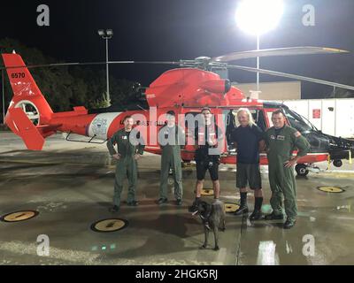 Ein Seefahrer und sein Hund sind nach der Erdung des Segelschiffs My Grace südlich von Dauphin Island Ende 28. August 2021 sicher. Eine US Coast Guard Air Station New Orleans MH-65 Dolphin Helikopter-Crew, die auf dem Weg zum U.S. Coast Guard Aviation Training Center Mobile für Hurican Ida Avoidance war, reagierte auf den Notruf und hisste das Paar in Sicherheit. Stockfoto