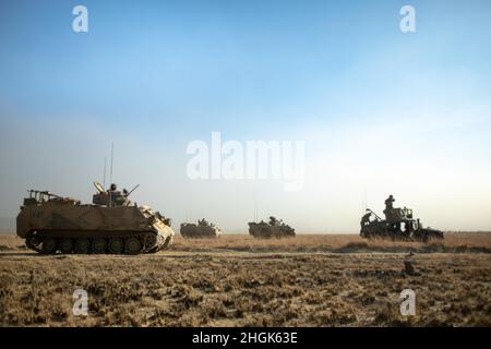 Australische Armee M113AS4 gepanzerte Personnellenträger passieren US-Marineinfanteristen mit kombiniertem Anti-Armor-Team Roter Zug, Marine Rotational Force – Darwin und halten während der Übung eine Phasenlinie für das Live-Feuer-Szenario Koolendong, Bradshaw Field Training Area, NT, Australien, 28. August 2021. Der Zug von CAAT Red war mit verschiedenen Waffen über ein Feld begrenzt, um eine wichtige Phasenlinie zu ergattern, die es anderen taktischen Fahrzeugen ermöglichte, durchzufahren und die Übung fortzusetzen. Übungen wie Koolendong bestätigen die Fähigkeit von MRF-D und der australischen Verteidigungskraft, Expeditions- und Kontrolloperatio durchzuführen Stockfoto