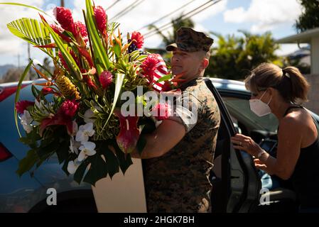 U.S. Marine Corps Master Sgt. Charles Hardesty, Operations Chief, Provost Marshal Office, Marine Corps Base Hawaii, liefert einen Blumenstrauß, der während eines Ausfalls der Gemeinschaftsblume an Bord der MCBH am 29. August 2021 erhalten wurde. Zur Unterstützung der 13 Dienstmitglieder, die in Afghanistan ihr Leben verloren, brachten Mitglieder der Gemeinde Blumen, die später für eine kleine, private Zeremonie am Pacific war Memorial platziert werden sollten. Stockfoto