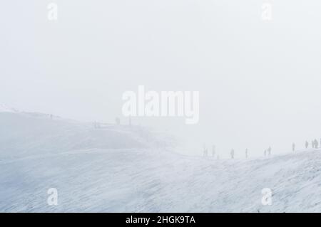 Tatra Mountains. Menschen, die auf einem in einer Wolke gehüllten Grat gehen. Winterlandschaft. Stockfoto