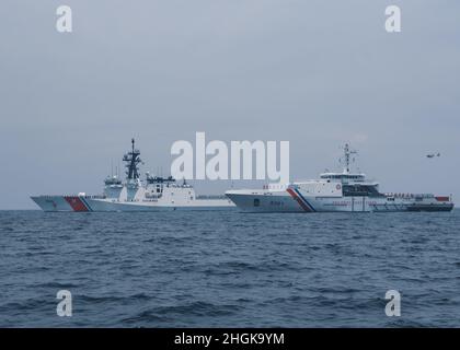 Die US-Küstenwache, Cutter Munro (links) und die philippinische Küstenwache, Offshore-Patrouille Gabriela Silang (rechts), ehren sich nach bilateralen Operationen und Übungen am 31. August 2021 in der Westphilippinischen See. Munro und die Besatzung sind derzeit im Westpazifik stationiert, um Allianzen und Partnerschaften zu stärken und die maritime Governance und Sicherheit in der Region zu verbessern. Stockfoto