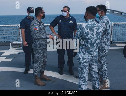 Der US-Küstenwache-Kapitän Blake Novak (Mitte), Kommandant des US-Küstenwachtschneiders Munro, spricht mit Mitgliedern der philippinischen Küstenwache während eines maritimen Engagements am 31. August 2021 in der Westphilippinischen See. Unter der taktischen Kontrolle der 7. US-Flotte führen der Cutter und die Crew einen professionellen Austausch und Übungen zum Aufbau von Kapazitäten mit den Partnerländern durch und patrouillieren und führen Operationen gemäß den Anweisungen durch. Stockfoto