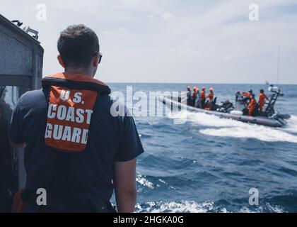 Der Kleinoffizier der US-Küstenwache der 3. Klasse Ethan Dorais, ein Bootsgefährte an Bord von Coast Guard Cutter Munro, sucht während einer Such- und Rettungsübung am 31. August 2021 in der Westphilippinischen See nach einem simulierten Mann über Bord mit Mitgliedern der philippinischen Küstenwache. Die Such- und Rettungsübung simulierte die bilaterale Reaktion beider Agenturen auf ein Schiff in Not. Stockfoto