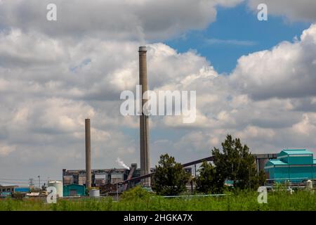 Industriestandort mit Rauch, der vom Rauchstapel aufsteigt Stockfoto