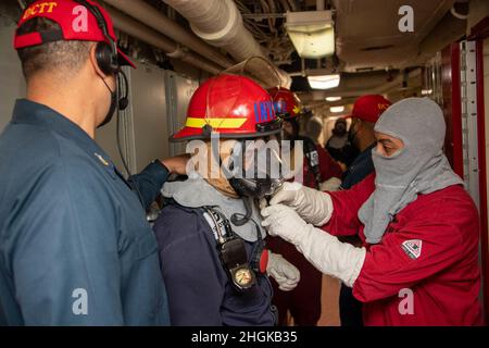 PAZIFISCHER OZEAN (31. August 2021) – Seeleute ziehen persönliche Schutzausrüstung (PSA) an, um auf eine Hauptübung im Weltraum an Bord des amphibischen Transportschiffes USS Portland (LPD 27) am 1. August zu reagieren. Portland, Teil der USS Essex Amphibious Ready Group (ARG), zusammen mit der Marine Expeditionary Unit (MEU) von 11th, Ist im Verantwortungsbereich der US-Flotte von 7th tätig, um die Interoperabilität mit Verbündeten und Partnern zu verbessern und als einsatzbereite Einsatztruppe für den Frieden und die Stabilität in der Indo-Pazifik-Region zu dienen. Stockfoto