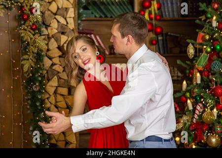 Schönes Paar tanzen im dekorierten Wohnzimmer von weihnachtsbaum feiern Neujahr Party Stockfoto