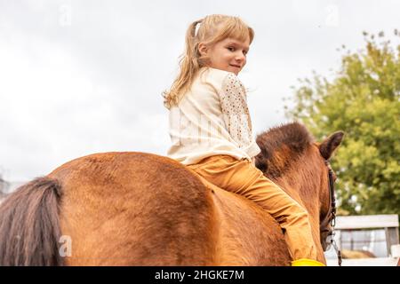 Kleines Mädchen reiten Pony ohne Sattel, Rückansicht Stockfoto