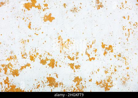 Abblätterndes Weißwasch an einer braunen, alten verputzten Wand mit gelben Flecken. Speicherplatz kopieren. Stockfoto