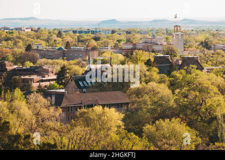 Ein Blick auf die Altstadt von Santa Fe, New Mexico, mit ihren Holz- und lehmbauten, die über die zahlreichen grünen Bäume blicken Stockfoto