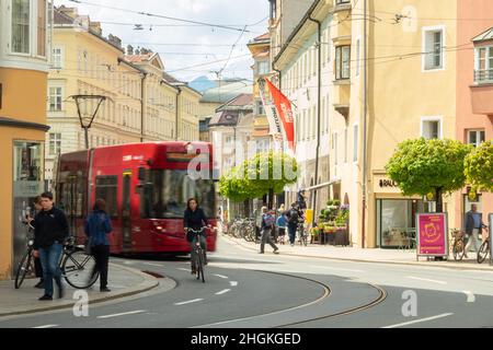 Innsbruck, Österreich - April 17th 2018: Eine rote Straßenbahn fährt an den historischen Gebäuden am Marktgraben vorbei Stockfoto