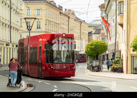 Innsbruck, Österreich - April 17th 2018: Eine rote Straßenbahn fährt an den historischen Gebäuden am Marktgraben vorbei Stockfoto