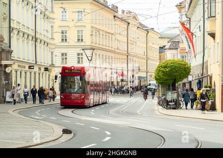 Innsbruck, Österreich - April 17th 2018: Eine rote Straßenbahn fährt an den historischen Gebäuden am Marktgraben vorbei Stockfoto