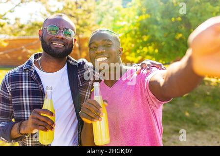 Zwei brasilianische Männer im Sommer Park bei Sonnenuntergang Sonne Licht Hintergrund Stockfoto
