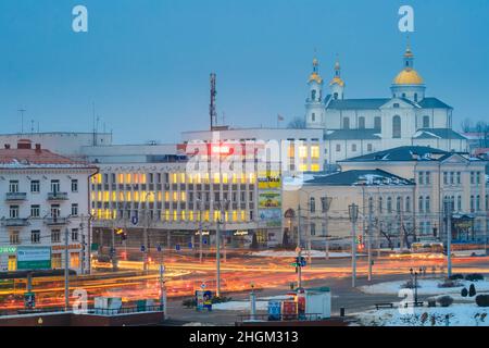 Vitebsk, Weißrussland. Nachtverkehr An Der Kreuzung Der Straßen Lenina Und Zamkovaya. Stadtzentrum In Der Nacht Beleuchtung In Der Wintersaison Stockfoto