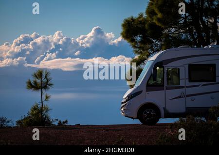 Modernes elegantes Wohnmobil gemütliches Haus geparkt abseits der Straße mit blauem Himmel und Wolken im Hintergrund. Konzept von Freiheit und Reiselebensstil für alternative Peo Stockfoto