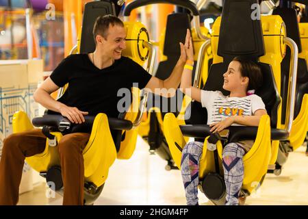 Lächelnd Familie reiten auf einer Achterbahnfahrt in einem Vergnügungspark. Stockfoto