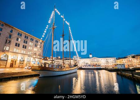 Helsinki, Finnland. Das Alte Hölzerne Segelschiff Ist Am City Pier, Jetty, Vertäut. Ungewöhnliches Cafe Restaurant Im Stadtzentrum Bei Beleuchtung Am Abend Oder Stockfoto