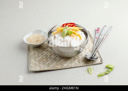 Tteokguk, koreanische Reissuppe in Scheiben geschnitten in Rinderbrühe, ovaler Reiskuchen in Brühe. Ein traditionelles Lunar New Year Gericht. Stockfoto