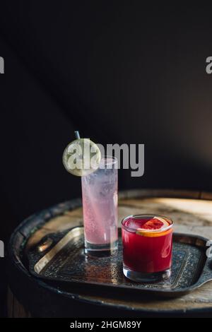 Hohe rosa Limonade und Blutorange-Cocktail in Steinglas auf Messingtablett Stockfoto