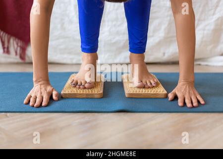 Frau, die auf einem Brett mit scharfen Nägeln steht - Füße und Beine aus der Nähe. Sadhus Boards Yoga Practice. Stockfoto