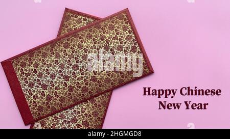 Happy Chinese New Year Text mit rotem Umschlag und rosa Hintergrund. Happy Chinese New Year Konzept. Stockfoto