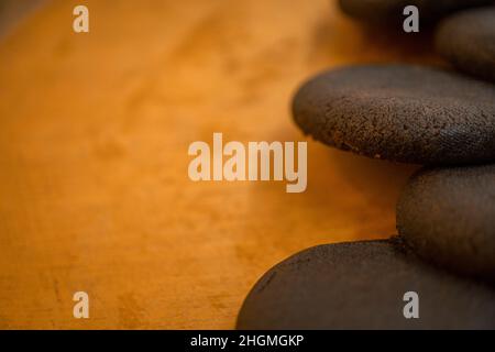 Nahaufnahme von Schokoladenkeksen über dem Holzteller, mit negativem Abstand. Dieses Bild ist perfekt für Lebensmittelbroschüre, Produktposter, Produktwerbung. Stockfoto
