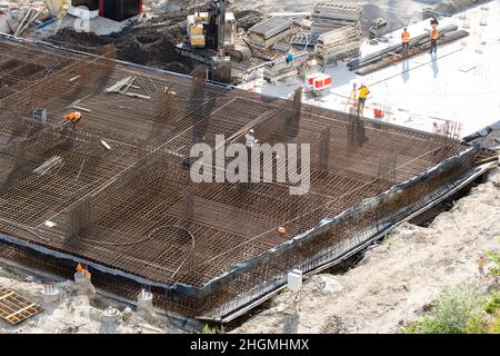 Nahaufnahme des Hausfundaments aus Betonschalungsblöcken, gefüllt mit Mörtel und Verstärkungsstäben Stockfoto