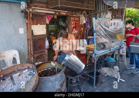 Ein Mann im Talat Phlu (Markt) in Thonburi, Bangkok, Thailand, stellt Khanom Khai her, einen Kuchen-ähnlichen Snack oder Dessert aus Eiern, Zucker und Mehl Stockfoto