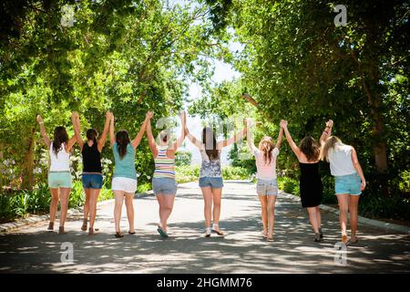 Eine Gruppe von Teenagern, die einen Geburtstag feiern. Freunde halten die Hände Stockfoto