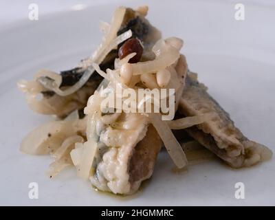 Sarde in Saor, marinierte venezianische Sardinen mit Zwiebeln, Rosinen und Pinienkernen aus Venedig, Italien Stockfoto