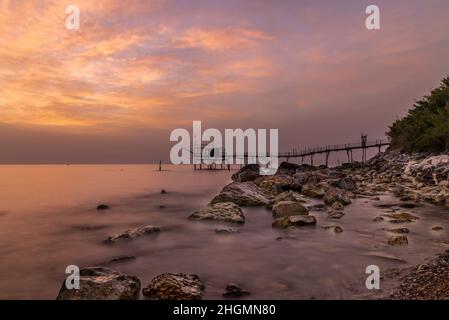 Juni 2021, San Vito Chietino, Abruzzen, Italien. Trabocchi Küste. Blick auf den Turchino Trabocco. Alte Fischmaschine im Morgenlicht mit seidigem Meer Stockfoto