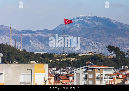 Bunte türkische Straßen mit niedrigen Häusern, Fässern mit heißem Wasser auf dem Dach und Sonnenkollektoren, die nationale türkische Flagge flattert im Hintergrund Stockfoto